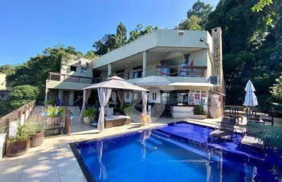 Casa com vista para o mar e cartões postais do rio.
