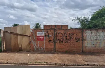 Terreno murado com água e luz ligados em rua de grande movimento