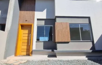 Casa nova com 2 dormitórios/ 1bwc social, 2 vagas garagem, amplo espaço de terreno na frente, em itapoá/sc.