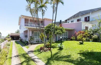 Casa com 4 quartos, suíte, churrasqueira, lareira, garagem coberta e lindo jardim.