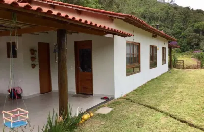 Sitio com ampla casa térrea com varanda ampla lateral.