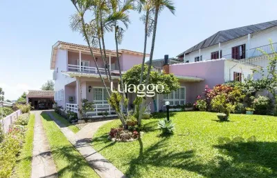 Casa com 4 quartos, suíte, churrasqueira, lareira, garagem coberta e lindo jardim.