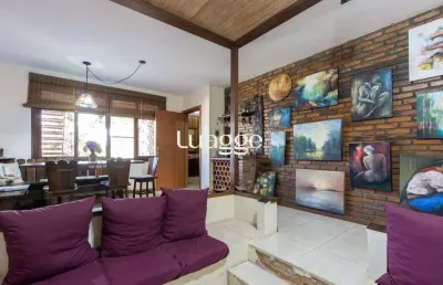 Casa de alvenaria, possui 3 dormitórios, uma suíte, hall de entrada, lavabo, living com lareira, cozinha ampla com armários, área gourmet com churrasqueira, corredor, pátio e 4 vagas de garagem, uma c