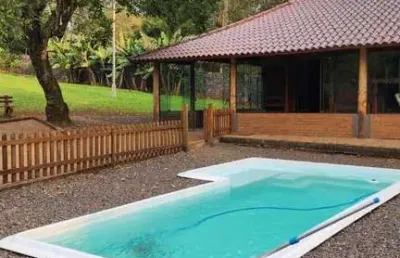 Casa com 2 dormitórios, piscina em terreno totalmente arborizado.