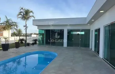 Casa em condomínio fechado com portaria 24 horas, piscina e grande área descoberta verde gramada.