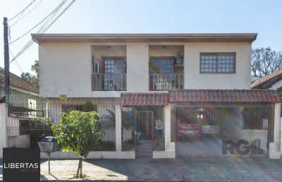Casa de alvenaria, 3 quartos, 1 suíte, 4 banheiros e 5 vagas de garagem.