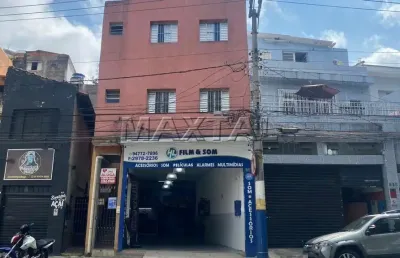 Prédio residencial de 2 andares com 4 apartamentos e um comércio no térreo.