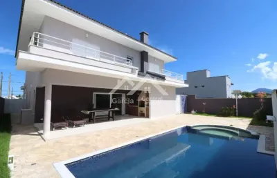 Sobrado de alto padrão em condomínio fechado em peruíbe com 4 suítes e área de lazer com piscina