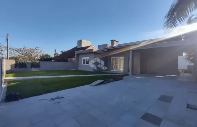 Casa térrea com 4 suítes + lavabo, amplo living com lareira e com acesso ao pátio em frente, quanto aos fundos da casa, em atlântida/rs.