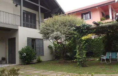 Casa a venda de 5 dormitórios mais banheiro social, localizada a poucos minutos da rua coberta de gramado.