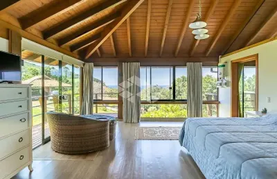 Casa de alto padrão em um condomínio de quatro casas com  04 dormitórios,sendo 03 suítes no morro da praia da ferrugem  , com vista espetacular.