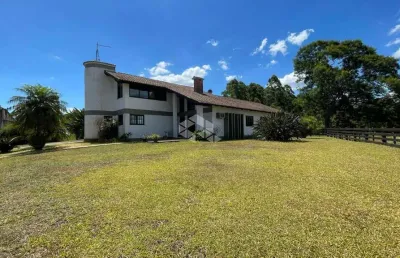 Área de terras com casa de 04 dormitórios e galpão/pavilhão.
