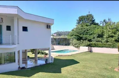 Residência de alto padrão com piscina e área de lazer em terreno generoso.