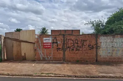 Terreno murado com água e luz ligados em rua de grande movimento