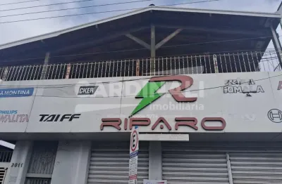 Salão no centro da cidade, com uma casa grande no piso superior.