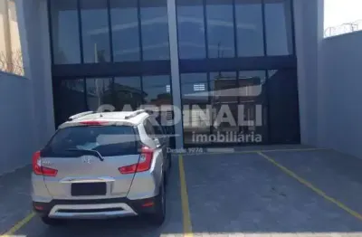 Salão comercial com sala, mezanino e estacionamento na frente.