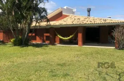 Espaçosa e acolhedora residência numas das esquinas em charmosa rua de atlântida, com imenso jardim, paisagismo, lareira,4 dormitórios, sendo duas suítes.