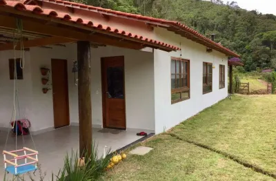 Sitio com ampla casa térrea com varanda ampla lateral.