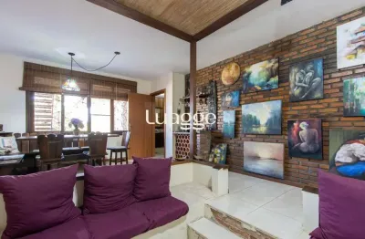 Casa de alvenaria, possui 3 dormitórios, uma suíte, hall de entrada, lavabo, living com lareira, cozinha ampla com armários, área gourmet com churrasqueira, corredor, pátio e 4 vagas de garagem, uma c