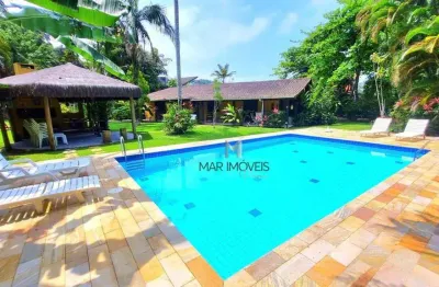 Aconhegante casa térrea com mais de 1000m² de área total em condomínio fechado na região da praia de pernambuco no guarujá!