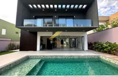 Casa à venda em condomínio na região do alphaville com 4 suítes, lazer comum e garagem para vários carros.