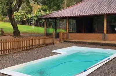 Casa com 2 dormitórios, piscina em terreno totalmente arborizado.