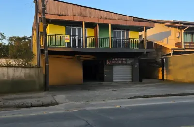 Sobrado com sala comercial e dois apartamentos com três e dois quartos.