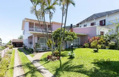 Casa com 4 quartos, suíte, churrasqueira, lareira, garagem coberta e lindo jardim.