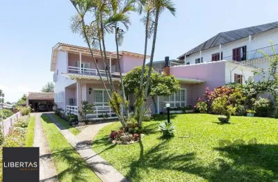 Casa com 4 quartos, suíte, churrasqueira, lareira, garagem coberta e lindo jardim.