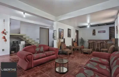 Casa com 300m², localizada na zona sul de Porto Alegre, com lareira, piscina e 3 vagas de garagem cobertas.