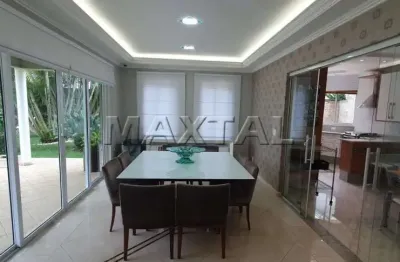 Casa de alto padrão 573m², 5 suítes, sala, tv, lareira, área gourmet e piscina aquecida com cascata.