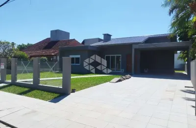 Casa térrea com 4 suítes + lavabo, amplo living com lareira e com acesso ao pátio em frente, quanto aos fundos da casa, em atlântida/rs.