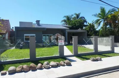 Casa térrea com 4 suítes + lavabo, amplo living com lareira e com acesso ao pátio em frente, quanto aos fundos da casa, em atlântida/rs.