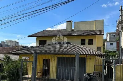 Casa à venda no Bairro Charqueadas em Caxias do Sul/RS, com três dormitórios, dois banheiros e duas vagas de garagem
