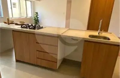 Apartamento à venda todo reformado em moema, com sala e cozinha integradas com ilha iluminação quente, aconchegante, ambientes integrados e piso de madeira restaurado.
