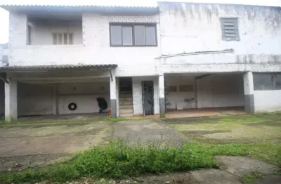 Prédio comercial com 22 boxes e casa residencial ideal para estacionamento e moradia.