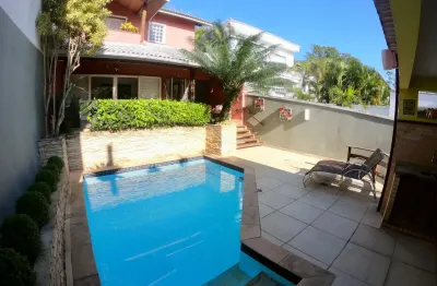 Linda casa com piscina e sauna, em condomínio arborizado, com lago e segurança 24 horas