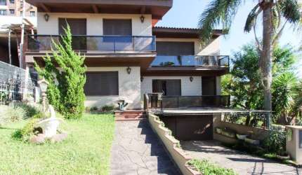 Casa a venda com 03 dormitórios, living 03 ambientes com vista para o Rio.