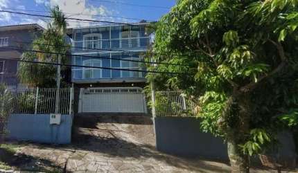 Ótima casa no bairro Teresópolis com 418m² construídos, de 3 pavimentos, em terreno com 400m² (16 x 25m). Possui hall de entrada, living amplo para 2 ambientes com lareira, sala de jantar, lavabo, cop