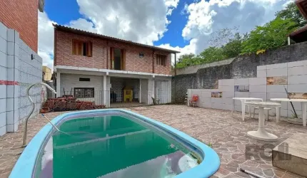 A casa da frente possui três quartos, banheiro social, living com dois ambientes e cozinha espaçosa.&lt;BR&gt;Já a casa dos fundos é dividida em dois andares: no térreo, dispõe de uma churrasqueira e 