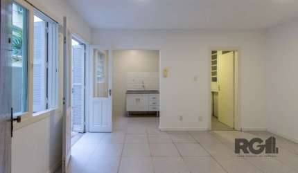 Apartamento JK térreo, no bairro Independência, com 26m² de área privativa, piso cerâmico, cozinha com pia e armário, banheiro social com armário e box de vidro, pequeno pátio com tanque. Condomínio c