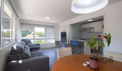 Apartamento mobiliado à venda, com 2 dormitórios, sendo 1 suíte, banheiro social, sala de estar e jantar em ambiente integrado, cozinha e área de serviço. O imóvel é todo envidraçado, o que garante ex