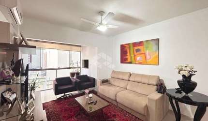 Apartamento central semimobiliado de 2 dormitórios.
