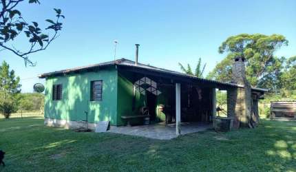 Casa de alvenaria com 2 dormitórios, sala e cozinha conjugado e churrasqueira na varanda.