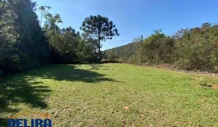 Terreno em meio a natureza com fonte dentro do terreno.