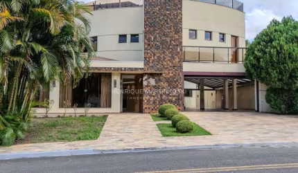 Casa em condomínio fechado com 5 suítes, 2 escritórios e mais de 700m² de área total – muito espaço, conforto e segurança em meio à natureza!