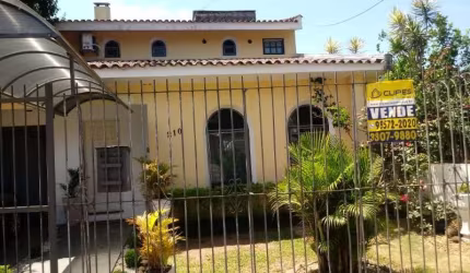 Vende bela casa no Bairro Teresópolis, com 3 suítes, salas amplas, cozinha mobilada, 5 banheiros, churrasqueira, pátio grande com piscina, garagem para 5 carros coberta, 1 garagem externa. Junto com C