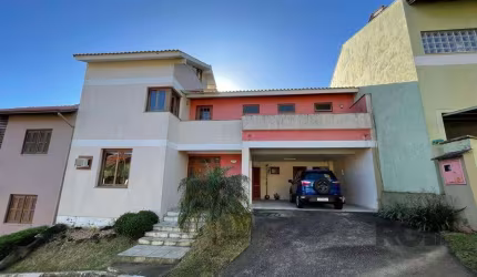 Casa em condomínio no bairro Cavalhada, zona sul de Porto Alegre. Possui amplo living em desnível com lareira, em conceito aberto integrando sala de estar, jantar e cozinha com churrasqueira, gabinete