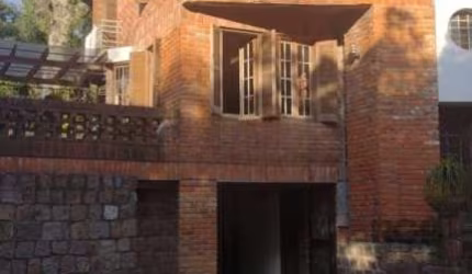 CASA DIFERENCIADA no morro Apamecor, projetada pelo proprietário arquiteto com madeiras e tijolos de demolição assim como aberturas. Porta da frente de metal, singular...Cozinha integrada à sala, piso