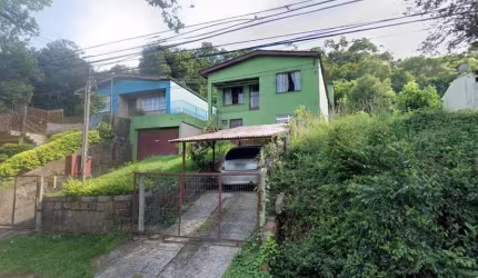Terreno com duas casas estilo sobrado. A casa principal possui na parte superior 2 dormitórios, living 2 ambientes, banheiro social, cozinha. Na parte inferior: living amplo estilo salão de festas com